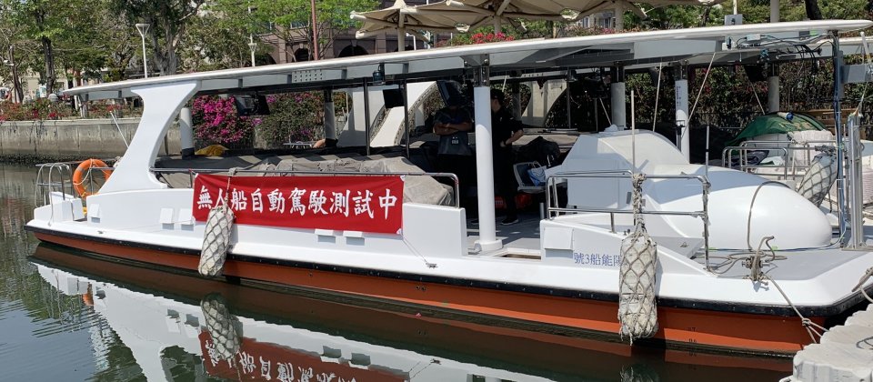 船舶中心與高雄市輪船公司合作,在愛河水域測試自駕船,測試時船身掛上自駕船測試中的布條供外界識別。
